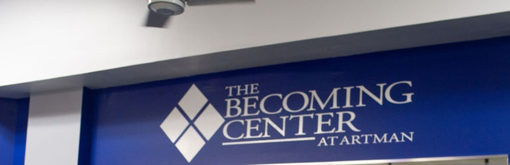 The blue and white logo for The Becoming Center at Artman