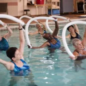 A group of Becoming Center members exercise in the heated pool