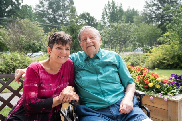 Daughter and father sit together outside at Artman