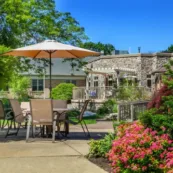 Flowers and a table with an umbrella outside at Artman